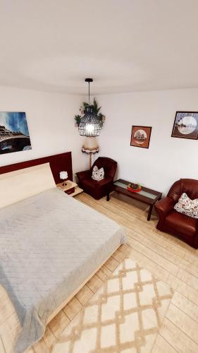 a bedroom with a large bed and two chairs at Casa Nicolae in Brăila