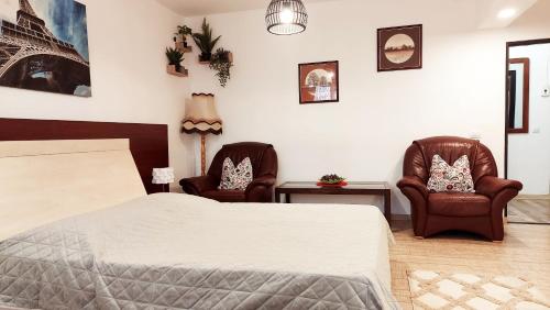 a bedroom with two chairs and a bed at Casa Nicolae in Brăila