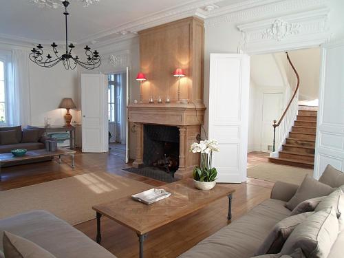 a living room with a couch and a fireplace at Domaine de Monciaux 2 piscines Tennis 40 Pers in Bourrou