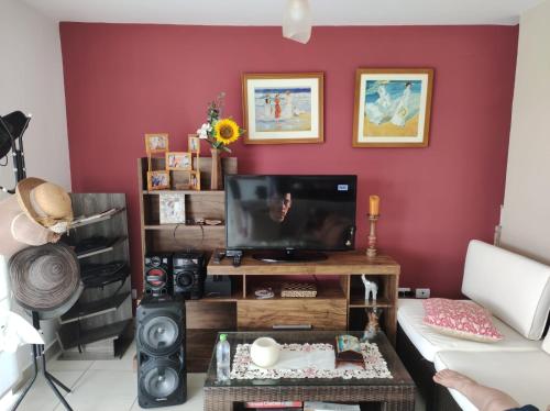 a living room with a red wall at Casa en condominio de playa para 12 personas, Asia in Rosario de Asia