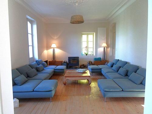 a living room with blue couches and a table at Domaine de Monciaux 2 piscines Tennis 40 Pers in Bourrou