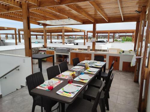 a dining room with a table and chairs and a kitchen at Casa en condominio de playa para 12 personas, Asia in Rosario de Asia