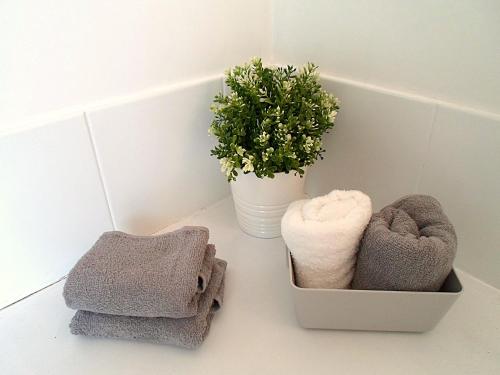 a bathroom with towels and a potted plant on a counter at Domaine de Monciaux 2 piscines Tennis 40 Pers in Bourrou