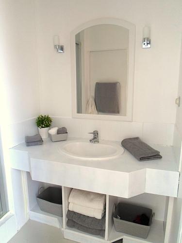 a white bathroom with a sink and a mirror at Domaine de Monciaux 2 piscines Tennis 40 Pers in Bourrou
