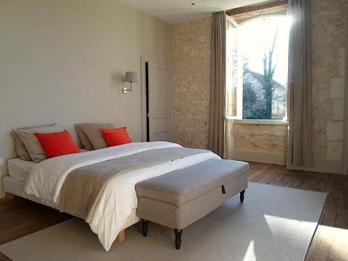 a bedroom with a bed with red pillows and a window at Domaine de Monciaux 2 piscines Tennis 40 Pers in Bourrou
