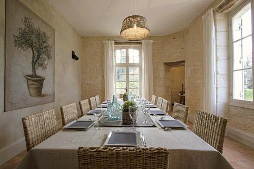 a dining room with a long table with chairs at Domaine de Monciaux 2 piscines Tennis 40 Pers in Bourrou