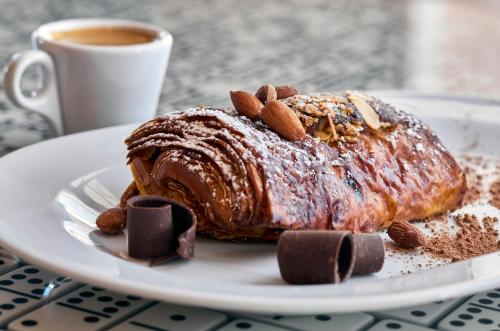 a chocolate cake on a plate with a cup of coffee at La Concha Key West, Autograph Collection in Key West