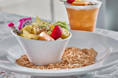 a bowl of fruit on a plate with a drink at La Concha Key West, Autograph Collection in Key West