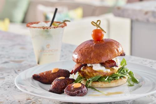 a white plate with a sandwich and some sausages at La Concha Key West, Autograph Collection in Key West
