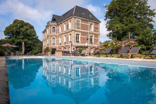 un grand bâtiment avec une piscine devant dans l'établissement Le Petit Château de Conteville, à Paluel