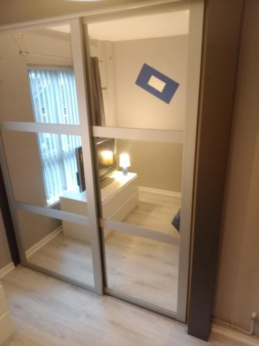 a sliding glass door with a mirror in a room at Belfast City Centre in Belfast