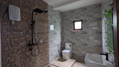 a bathroom with a shower and a toilet and a sink at Doven nest villa in Tangalle