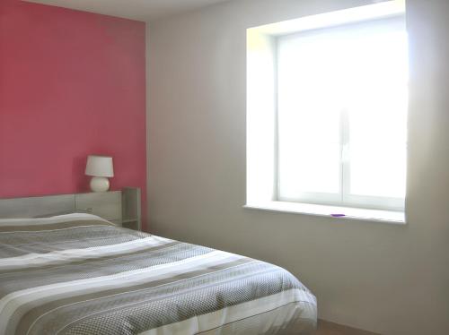 a bedroom with a bed and a window at Maison charmante à La Vineuse avec jardin clôturé in La Vineuse