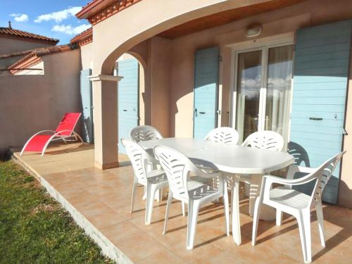 a white table and chairs on a patio at Maison charmante à Homps + Jardin avec vue sur le lac in Homps
