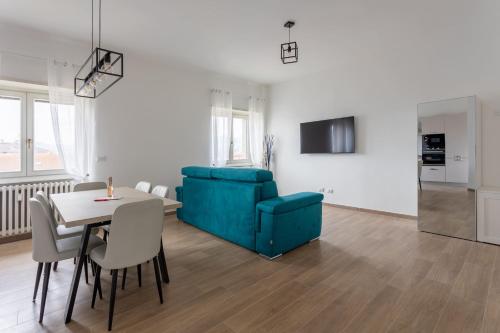 a living room with a table and a blue couch at Arya's Corner by the Lake - Parcheggio - Vista lago in Arona
