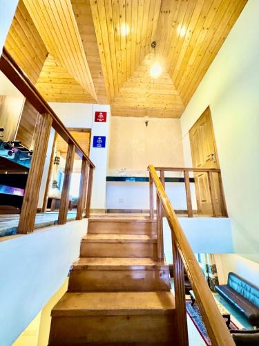 a staircase in a house with wooden ceilings at The Sky Mountain Kufri I Serviced Villa I Balcony I Valley and Mountain View I Family Groups & Bonfire I Memories & Enjoyment Villa I Operated Charvi Retreat by Exotic Stays in Kūfrī