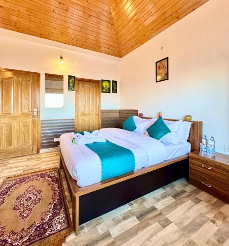 a bedroom with a large bed with a wooden ceiling at The Sky Mountain Kufri I Serviced Villa I Balcony I Valley and Mountain View I Family Groups & Bonfire I Memories & Enjoyment Villa I Operated Charvi Retreat by Exotic Stays in Kūfrī