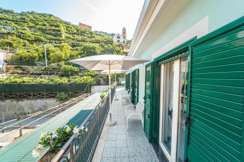 a balcony with a table and an umbrella at Residenza Sant'Angelo - Art Apartment in Minori