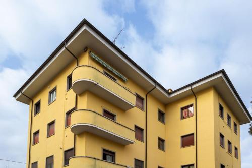 a yellow building with a sky in the background at Arya's Corner by the Lake - Parcheggio - Vista lago in Arona