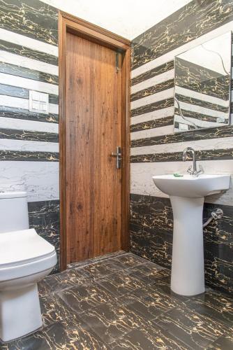 a bathroom with a toilet and a sink at The Sky Mountain Kufri I Serviced Villa I Balcony I Valley and Mountain View I Family Groups & Bonfire I Memories & Enjoyment Villa I Operated Charvi Retreat by Exotic Stays in Kūfrī