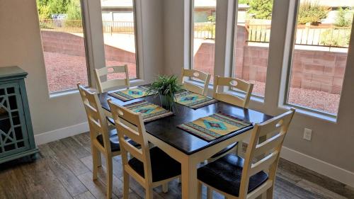 a dining room with a table and chairs and a fireplace at Coral Cliff View - Amazing Views and Pool in Kanab