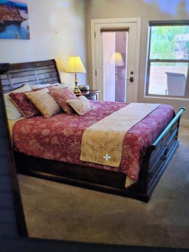 a bedroom with a large bed with a red blanket at Coral Cliff View - Amazing Views and Pool in Kanab
