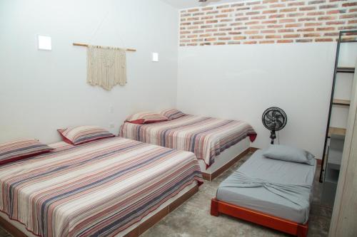 a bedroom with two beds and a chair in it at Hacienda San Nicolas -Pto Boyaca in Puerto Triunfo
