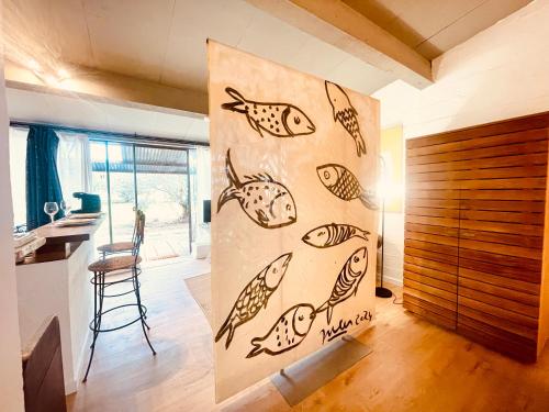 a kitchen with a painting of fish on the wall at CHEZ BABOU studio d'artistes avec piscine, parking in Nîmes
