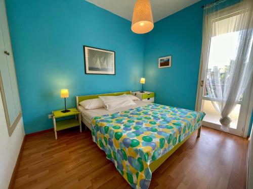 una camera da letto con un letto e una parete blu di Colorful house with pool and garden a Porto Santa Margherita di Caorle