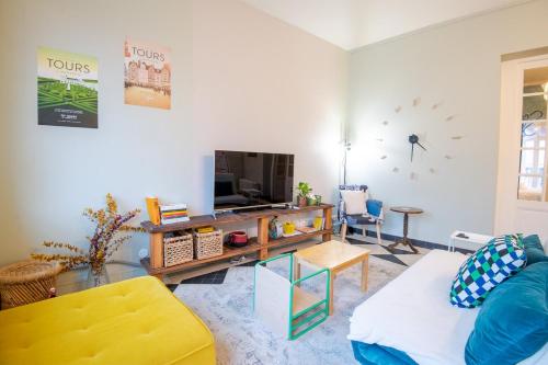 un salon avec un canapé et une télévision dans l'établissement Le 54 - Tours, à Tours