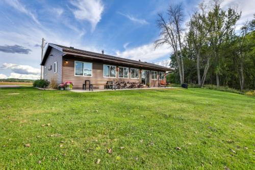 a house with a large grassy field in front of it at Riverfront Home with Private Dock in Wisconsin Dells in Lyndon Station
