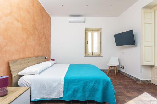a bedroom with a bed with a blue blanket at Badimà - Villa con piscina in Aci SantʼAntonio
