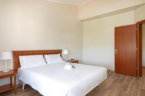 a bedroom with a white bed and a wooden cabinet at B&B Hotel Affi - Lago di Garda in Affi