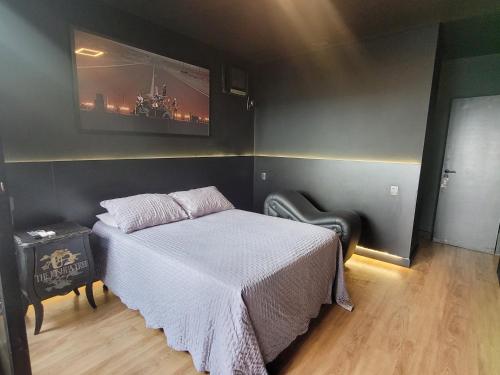 a bedroom with a bed and a tv on the wall at Morumbi, Apartamento Pub, SPA com hidromassagem, PISCINA Aquecida PRIVATIVA, LAREIRA, tudo que você precisa para descansar, trabalhar ou realizar aquela comemoração! Com total conforto e PRIVACIDADE! O Apt Nota 10 de SP! in Sao Paulo