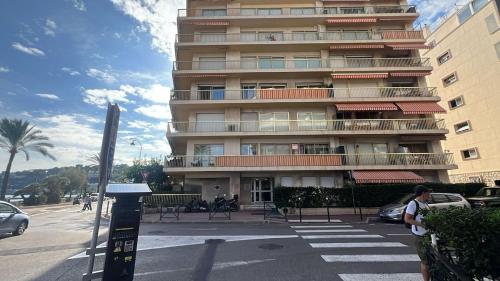 un grand bâtiment avec un compteur de stationnement devant lui dans l'établissement Charmant studio en bord de mer, à Roquebrune-Cap-Martin