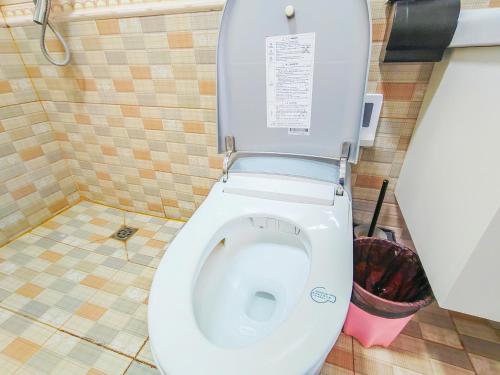 a white toilet in a bathroom with a trash can at 凨凪凮夙雪山观景酒店 in Baisha