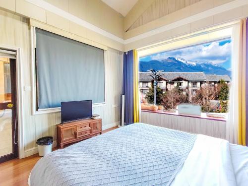 a bedroom with a bed and a large window at 凨凪凮夙雪山观景酒店 in Baisha