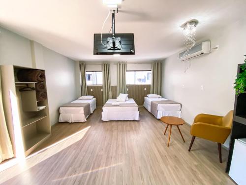 a living room with two beds and a couch at Hotel Zata - Premium in Criciúma