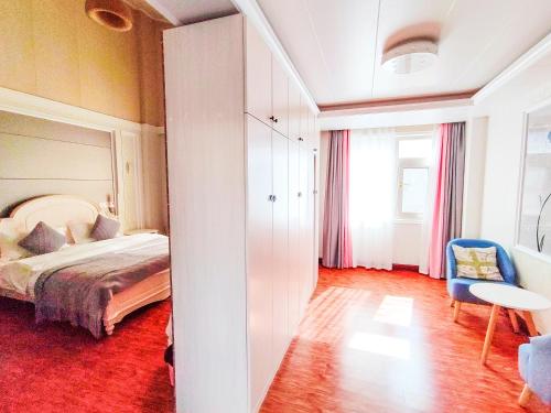 a bedroom with a bed and a table and a chair at 凨凪凮夙雪山观景酒店 in Baisha