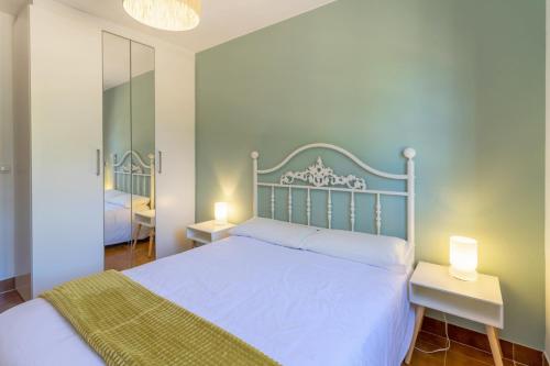 a bedroom with a white bed with two tables and two lamps at Ca la Goyi in Caldes de Malavella
