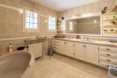 a bathroom with a tub and two sinks and a mirror at Ca la Goyi in Caldes de Malavella