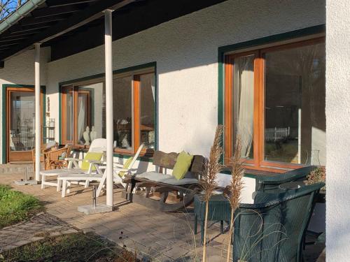 a patio with chairs and tables on a house at Ferienhaus Harmony in Übersee