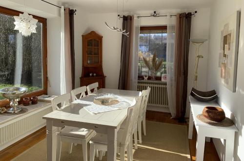 a white dining room with a white table and chairs at Ferienhaus Harmony in Übersee