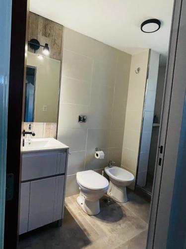 a bathroom with a toilet and a sink at Los plátanos 1 y 2 in Junín