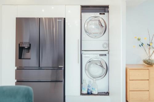 a kitchen with a refrigerator and a washer and dryer at 5 Bed Family Home- Free Parking in Woodham Ferrers Station