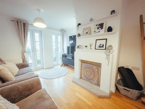 a living room with a couch and a fireplace at 5 Bed Family Home- Free Parking in Woodham Ferrers Station