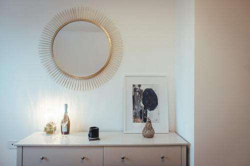 a mirror on a wall above a dresser in a room at 5 Bed Family Home- Free Parking in Woodham Ferrers Station