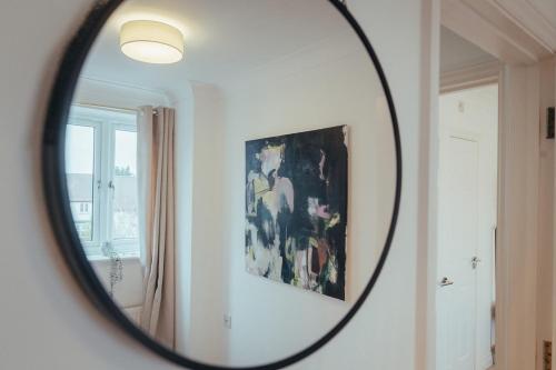 a mirror in a room with a painting at 5 Bed Family Home- Free Parking in Woodham Ferrers Station