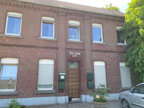 a red brick building with a brown door at Worker Space Bedburg Hau in Bedburg Hau