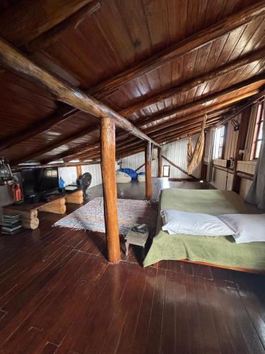 a bed in a room with a wooden ceiling at Casa Mágica in Praia do Rosa